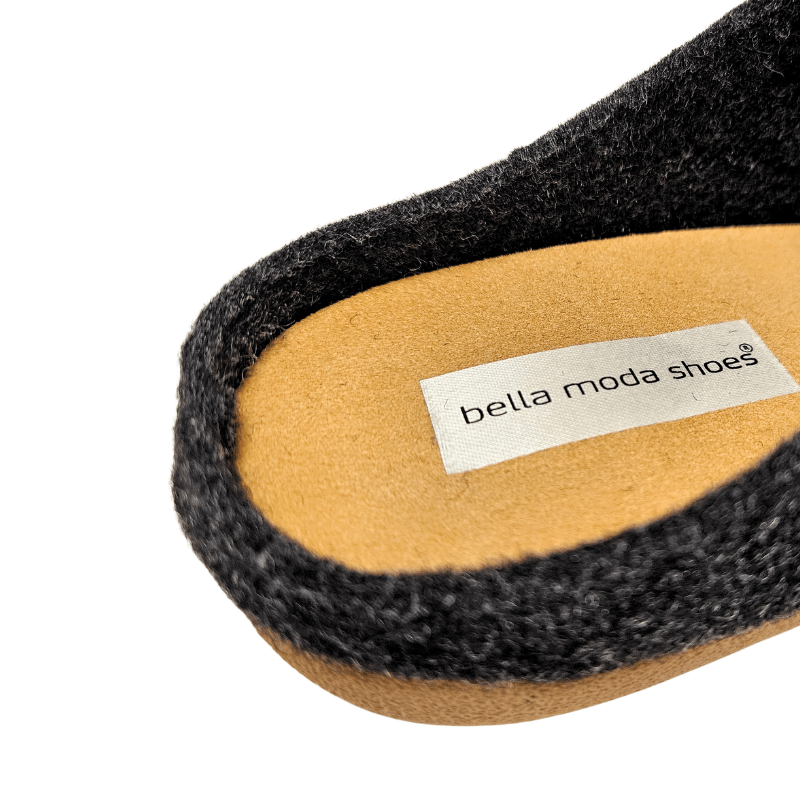 Nærbilde av den antrasittgrå ullhjemmeskoens innersåle med Bella Moda-merket tydelig