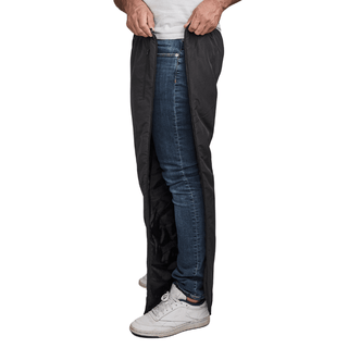 Mann åpner svarte Dobsom termobukser i siden, over blå jeans og hvite joggesko