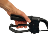 Nærbilde av en hånd som holder det ergonomiske svarte håndtaket og bremsehåndtaket på en rullator